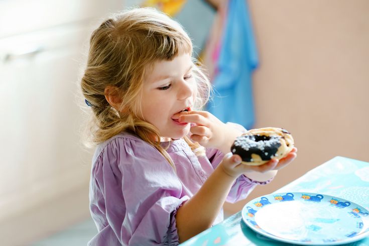 Happy girl enjoying a chocolate donut